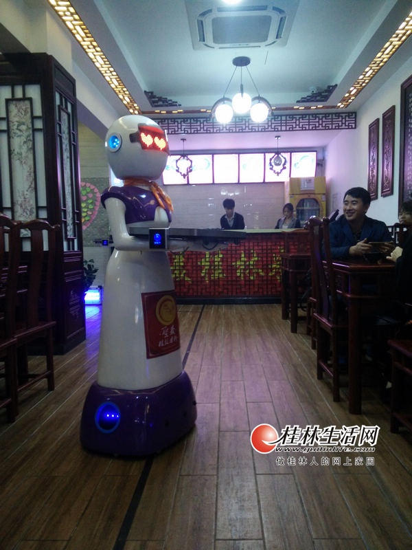 機(jī)器人將米粉送到了客人面前,客人都感到很新奇。